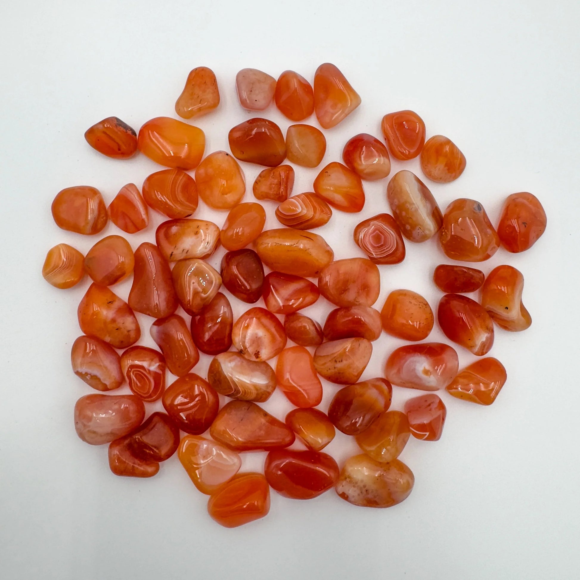 Close-up detail of Grade AA Carnelian tumbled stone showing natural orange, red tones and texture