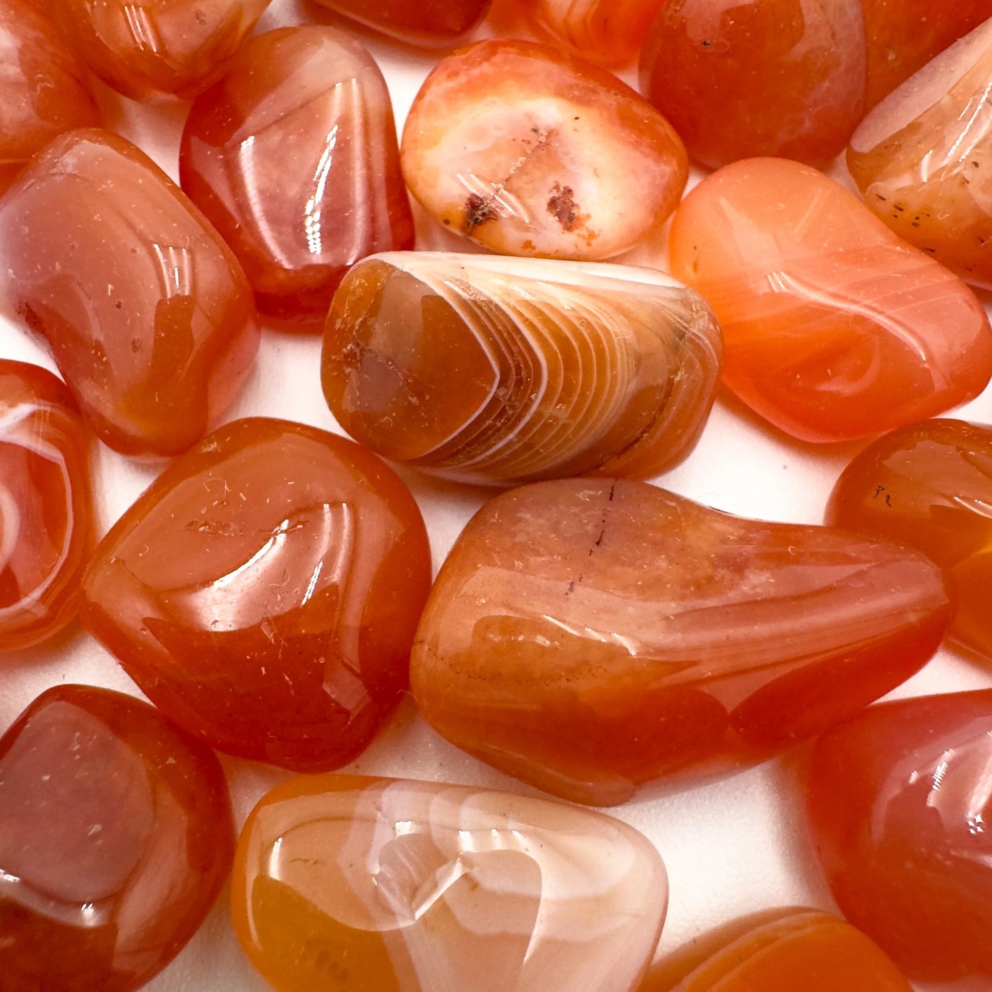 Side profile of Grade AA Carnelian tumbled stone with natural form and inclusions