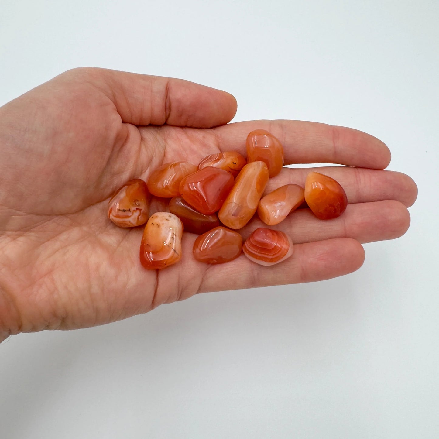 Back view of Grade AA Carnelian tumbled stone showing natural surface