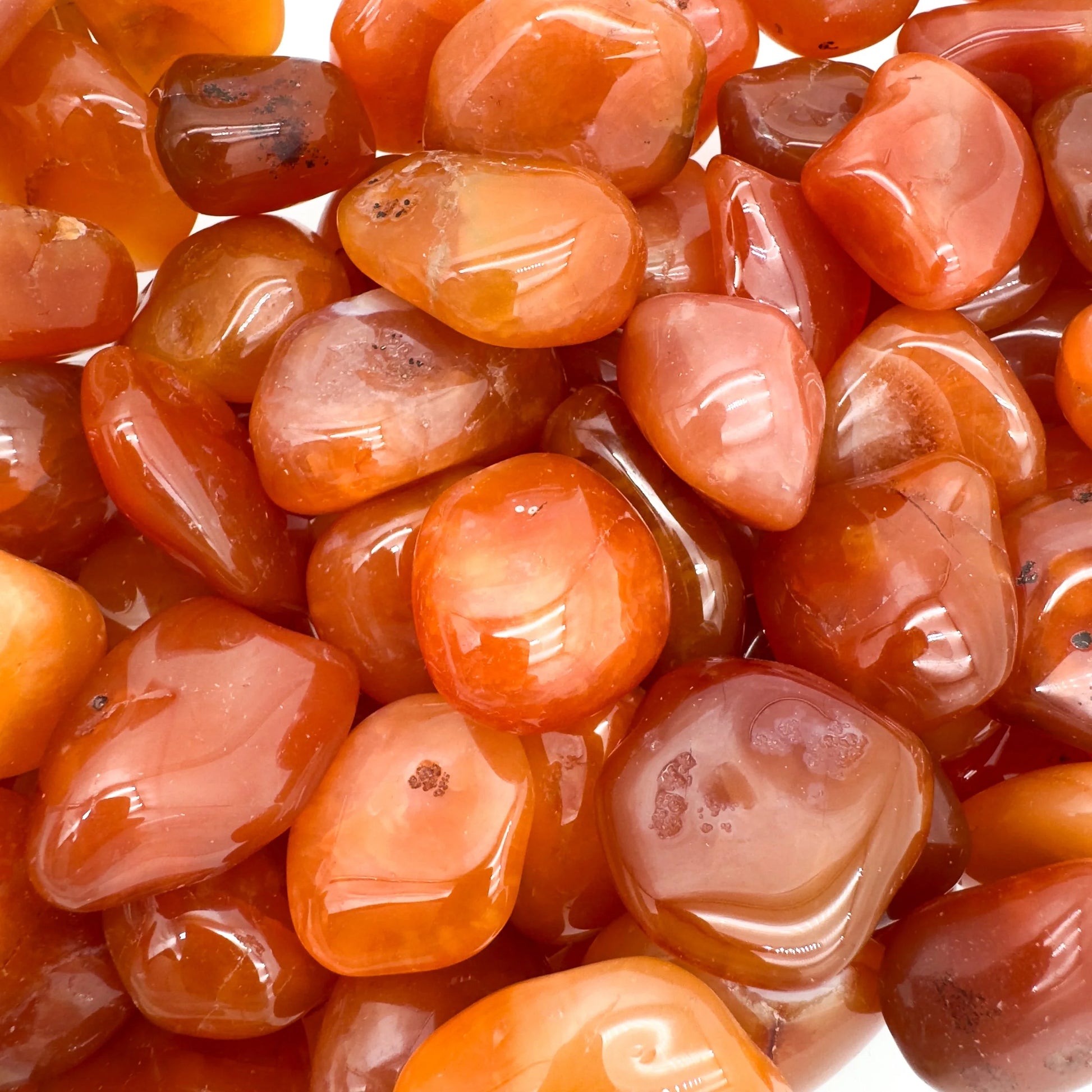 Side profile of Grade AA Carnelian tumbled stone with natural form and inclusions