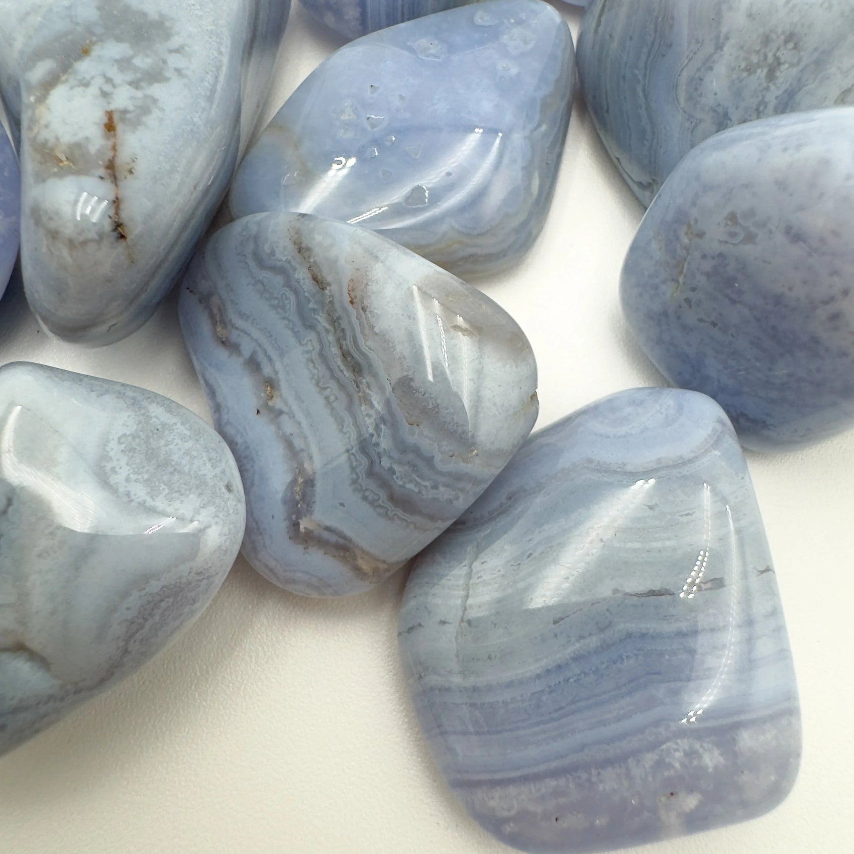 Edge-on view of Blue Lace Agate tumbled stone, showing subtle veining.