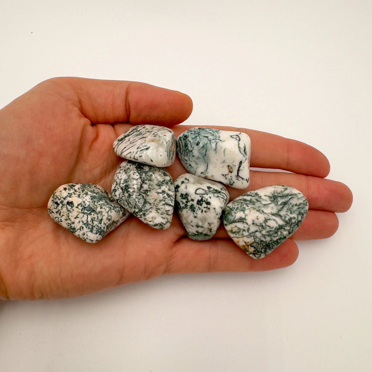 Reverse side of green Tree Agate tumbled stone, sourced from Botswana, showing earthy tone.
