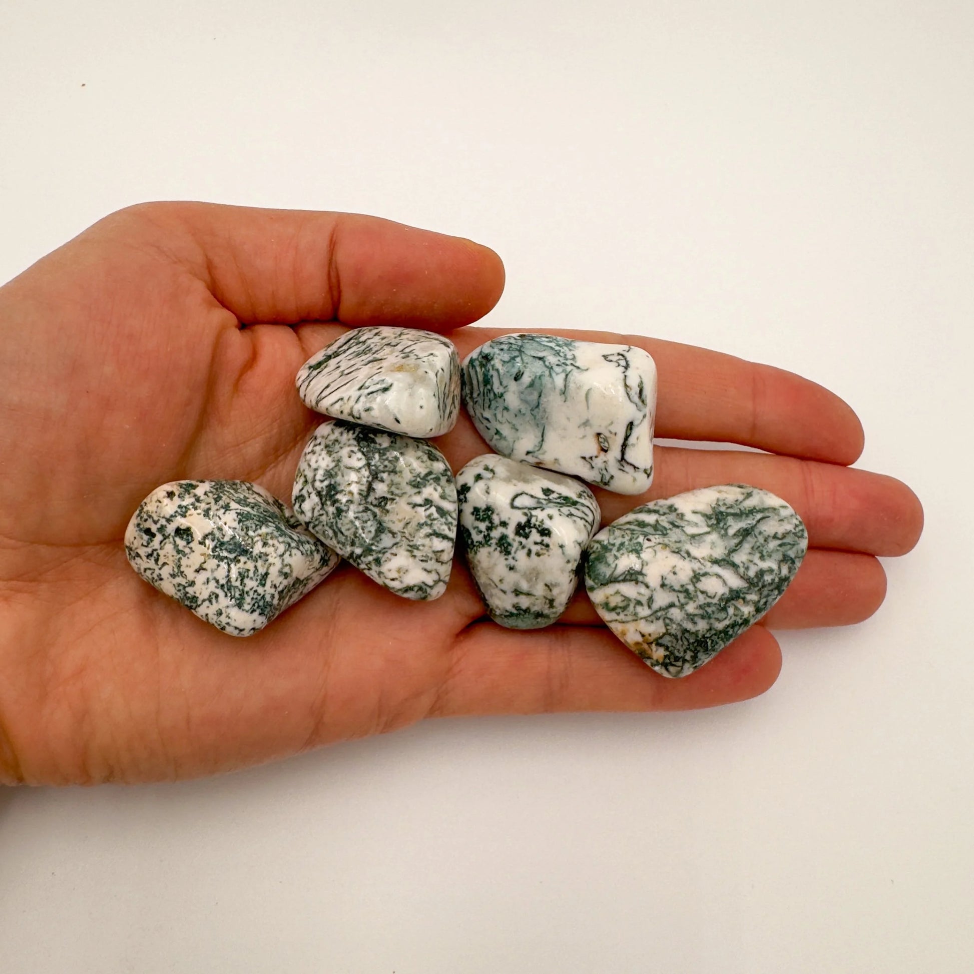 Reverse side of green Tree Agate tumbled stone, sourced from Botswana, showing earthy tone.