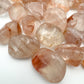 Edge view of Fire Quartz tumbled stone, kept near for Grounding, from Madagascar.