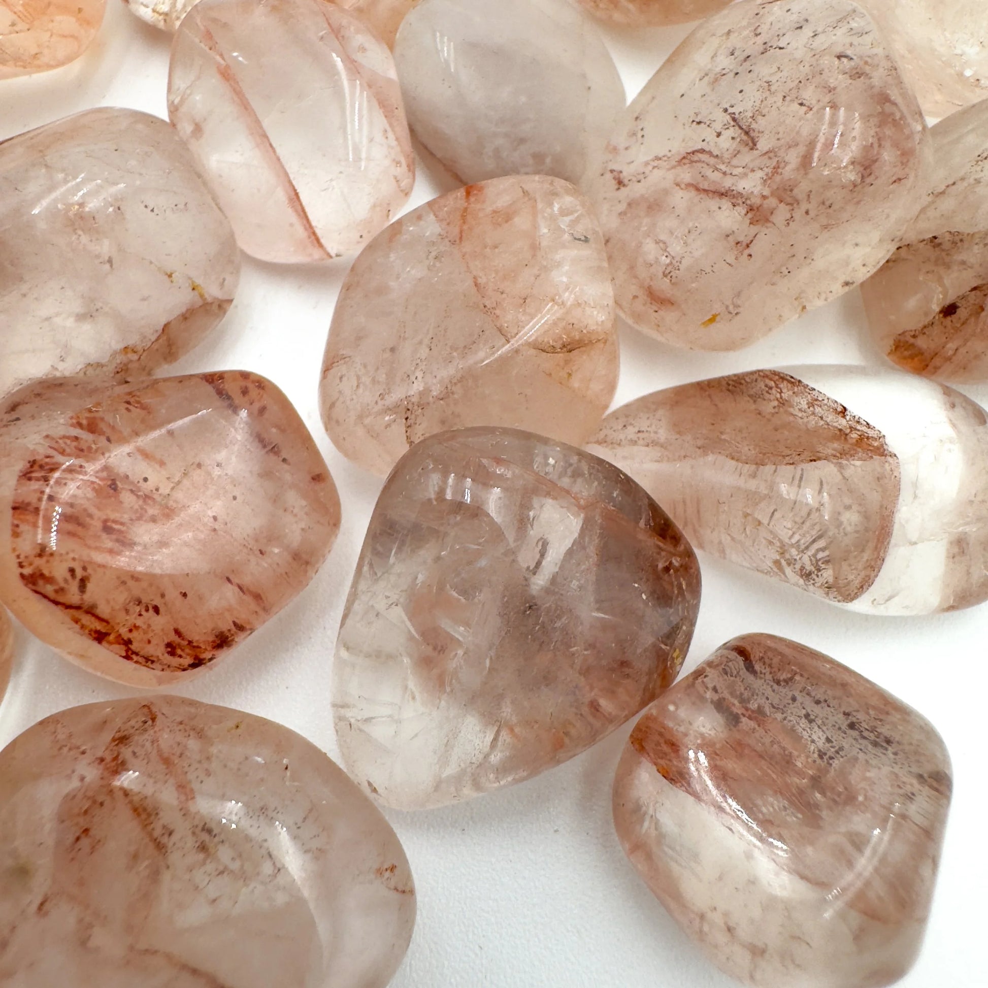 Bird's-eye view of red Fire Quartz tumbled stone, showing soft luster, Madagascar-sourced.