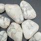 In-hand view of one Howlite tumbled stone for scale, Zimbabwe-sourced, from Masvingo, Zimbabwe.