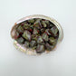 Color detail of Dragon Bloodstone tumbled stone, sourced from South Africa, showing subtle veining.