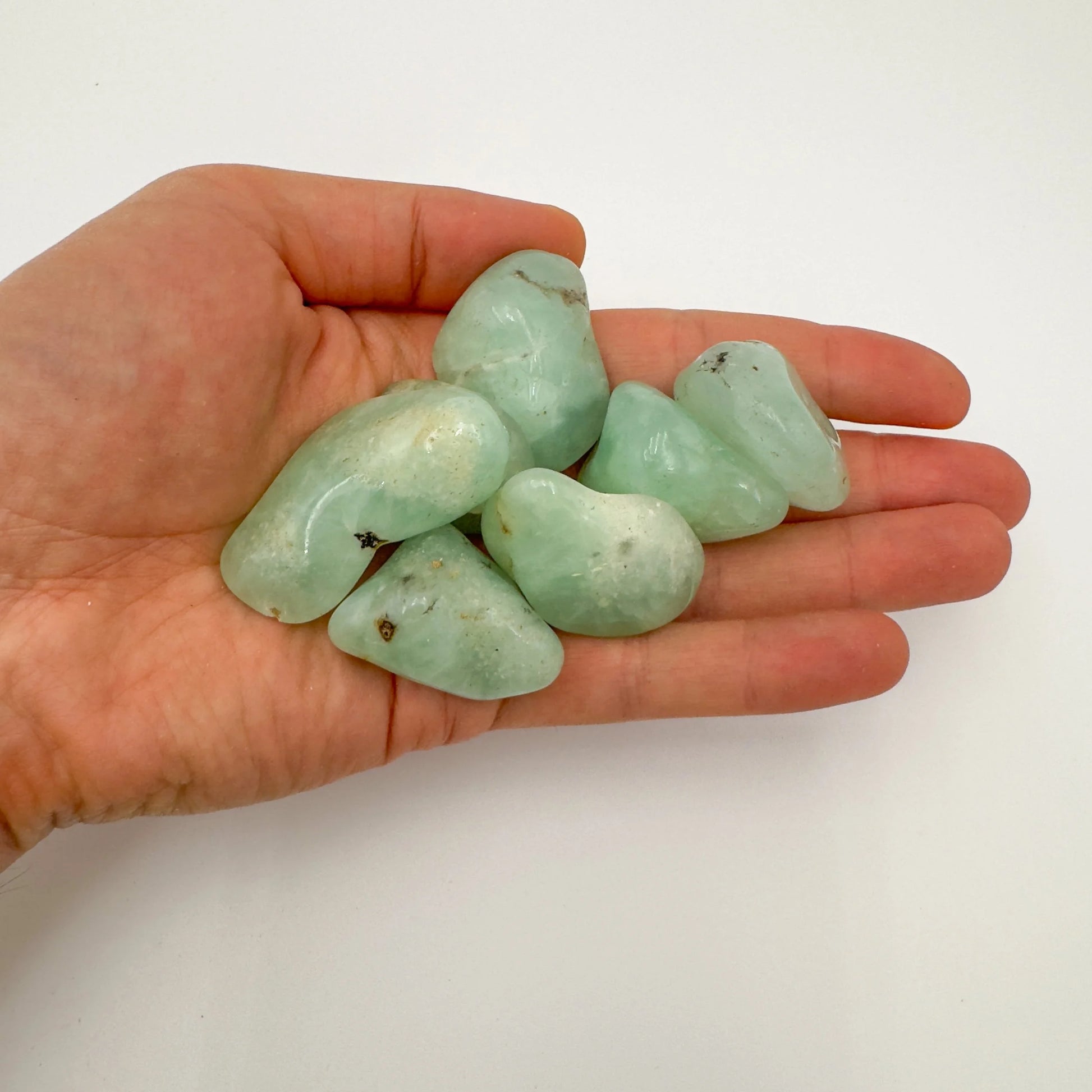Back view of Grade AA Prehnite tumbled stone showing natural surface
