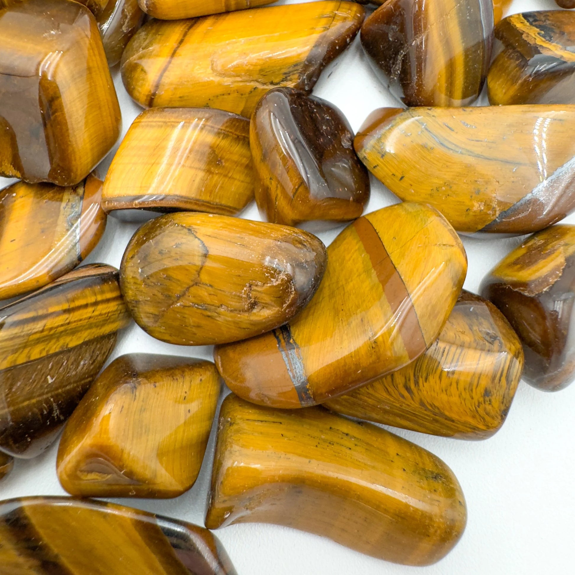 Profile shot of Tiger Eye tumbled stone, showing natural sheen.