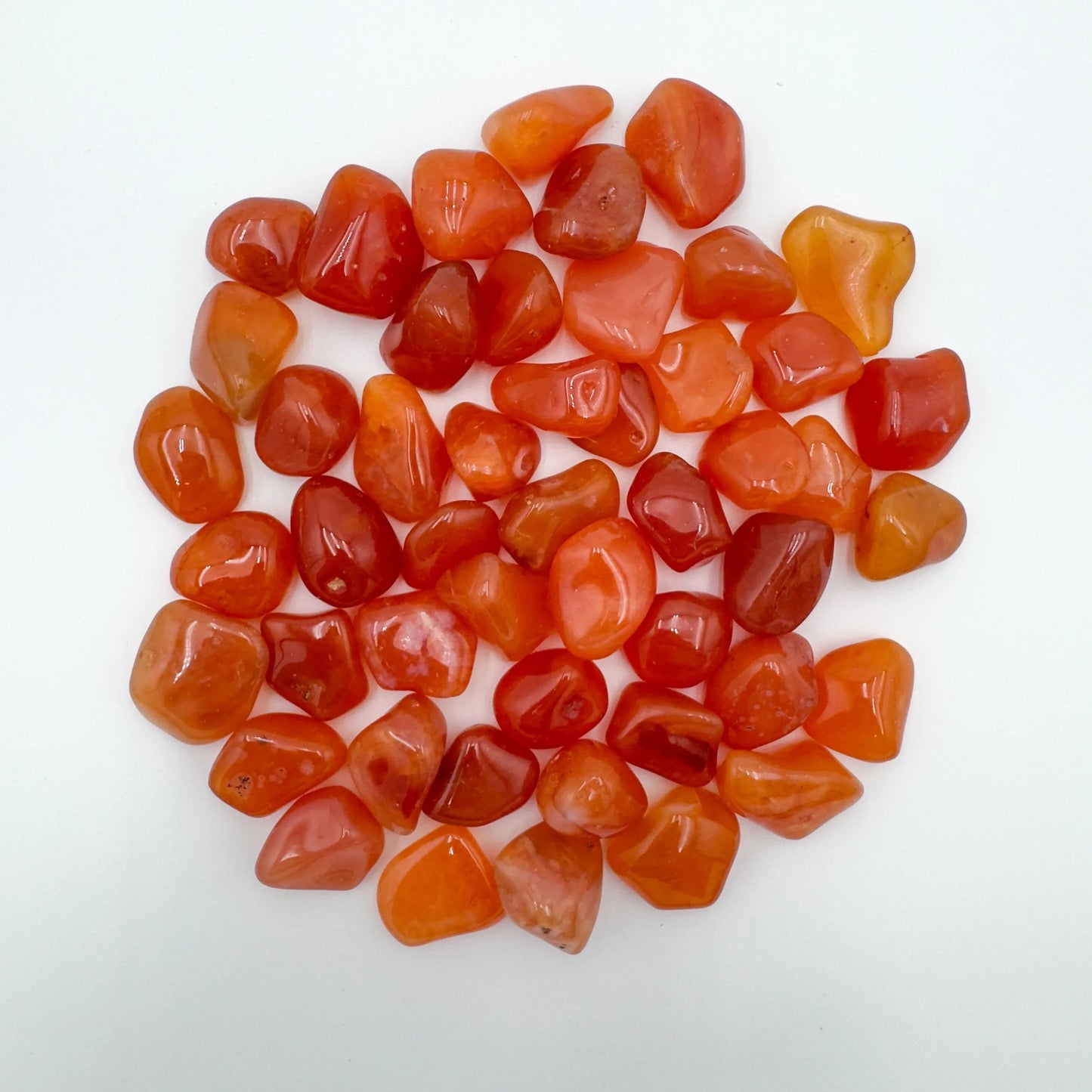 Close-up detail of Grade AA Carnelian tumbled stone showing natural orange, red tones and texture