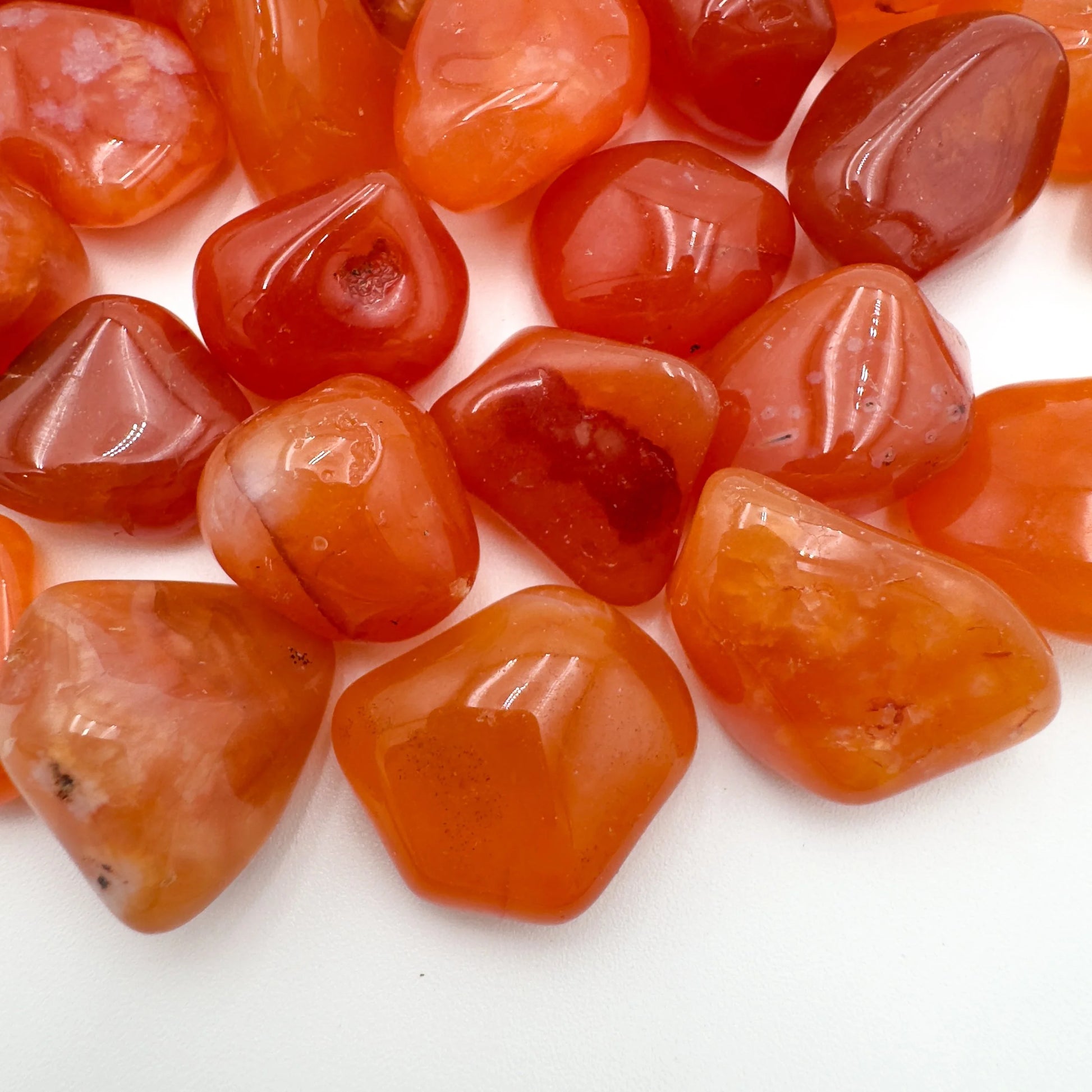Side profile of Grade AA Carnelian tumbled stone with natural form and inclusions