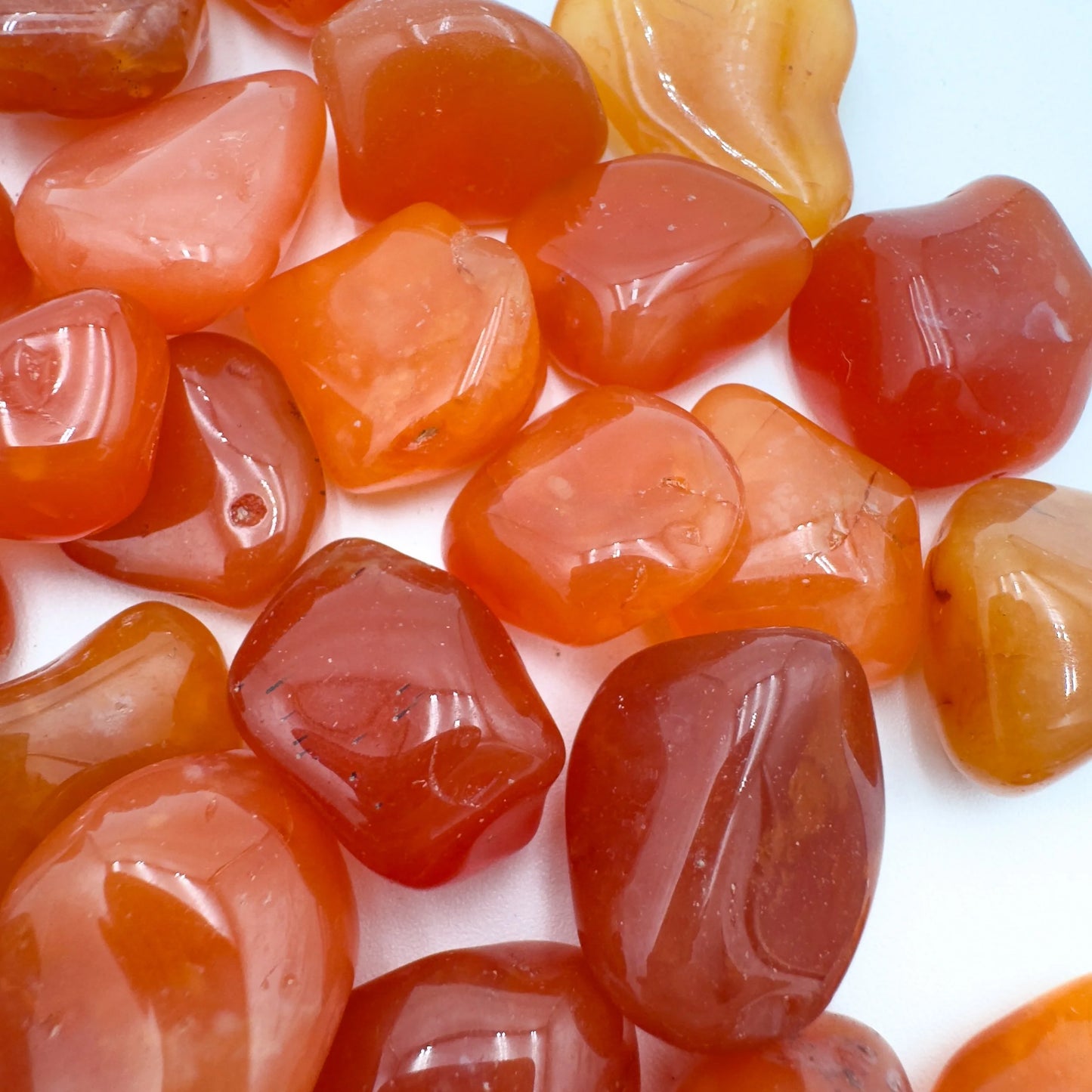 Grade aa carnelian tumbled stone held in hand for size reference