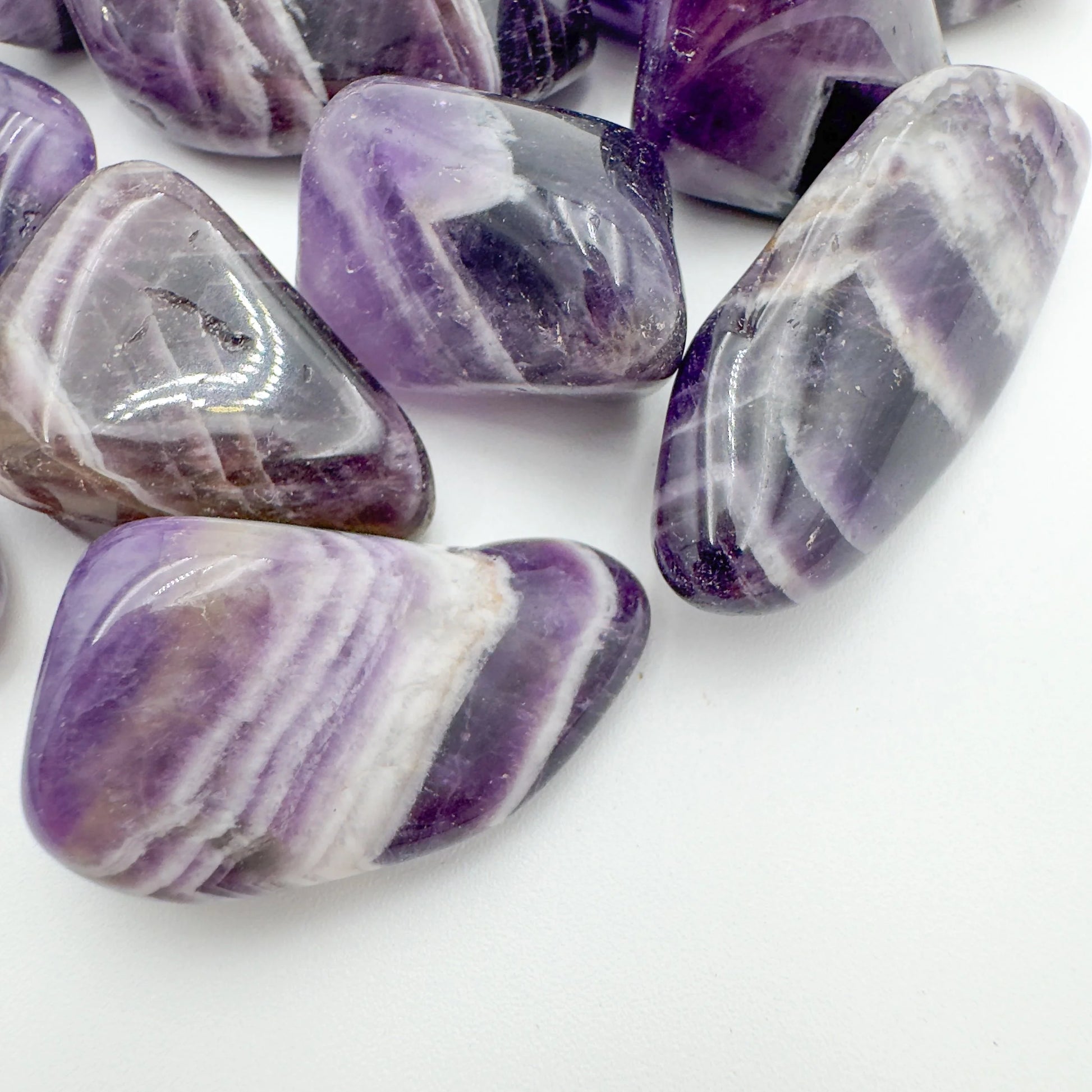Side perspective of Chevron Amethyst tumbled stone, often worked with for Intuition.