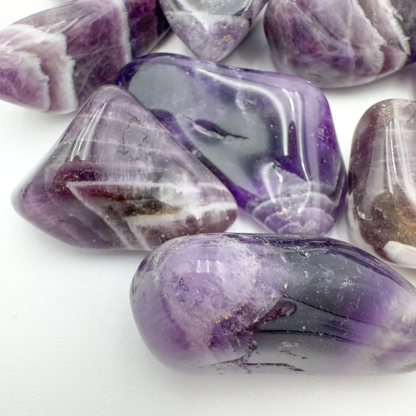 Overhead view of Chevron Amethyst tumbled stone, showing characteristic finish, sourced from Zambia.
