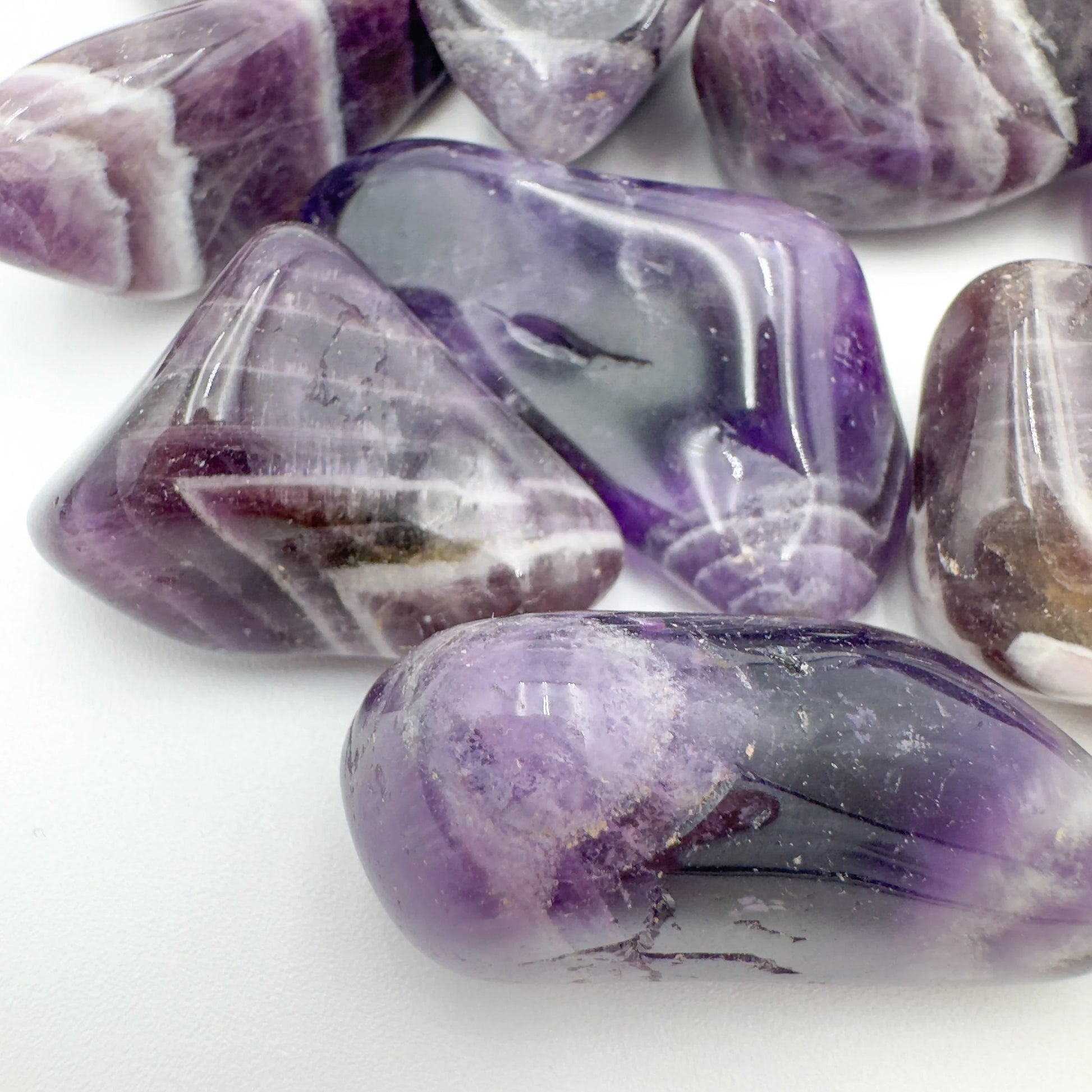 Overhead view of Chevron Amethyst tumbled stone, showing characteristic finish, sourced from Zambia.