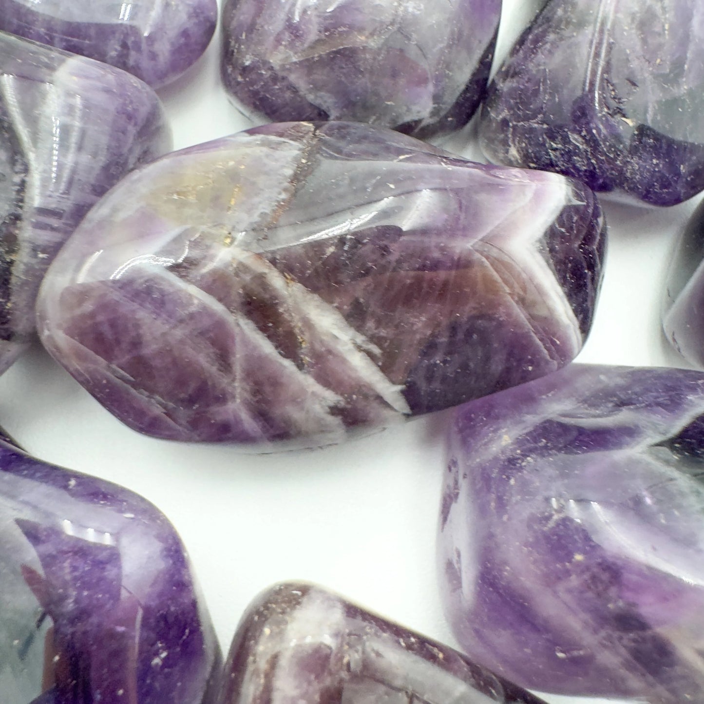 In-hand view of a Chevron Amethyst tumbled stone for Intuition, Zambia-sourced.