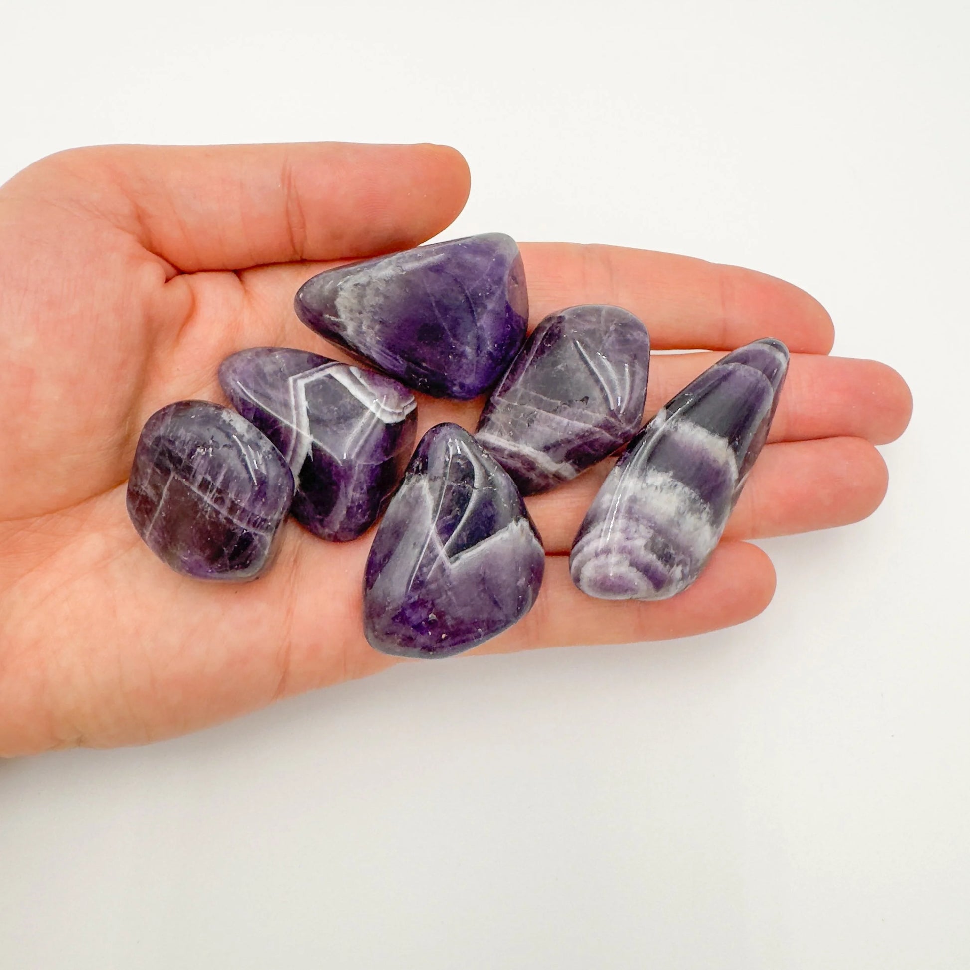Detail shot of Grade AA Chevron Amethyst tumbled stone under natural light