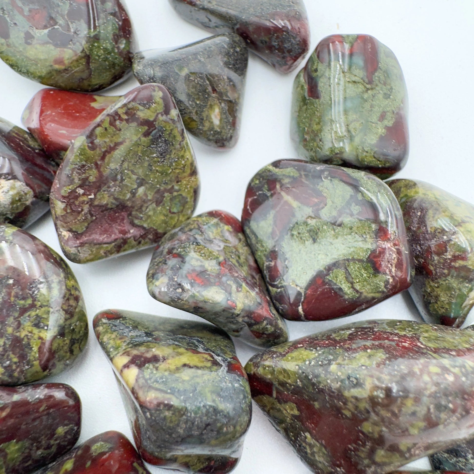 Size comparison with a Dragon Bloodstone tumbled stone for Confidence and Energy.