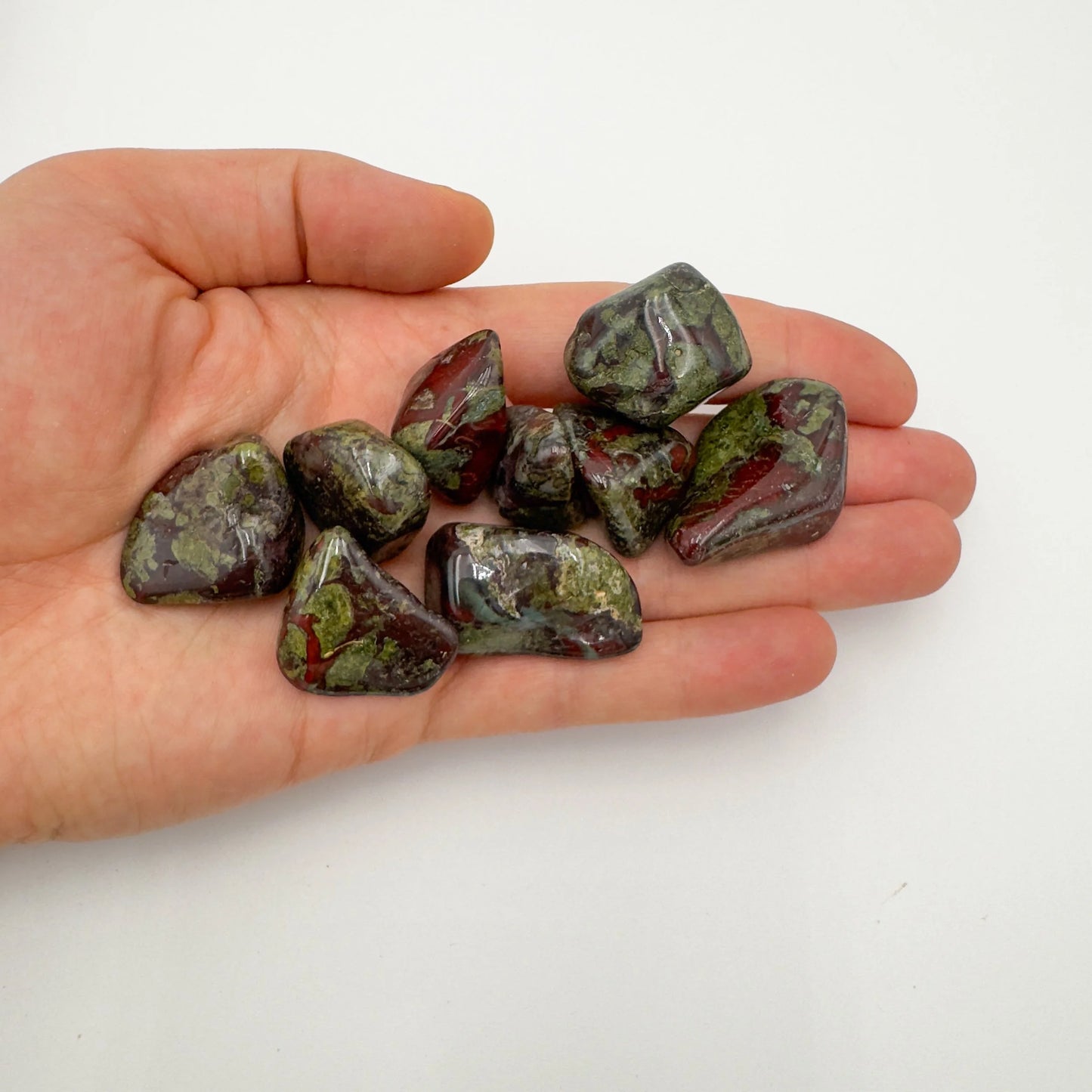 Natural light context of Dragon Bloodstone tumbled stone, from Limpopo, South Africa, with subtle natural color showing through.
