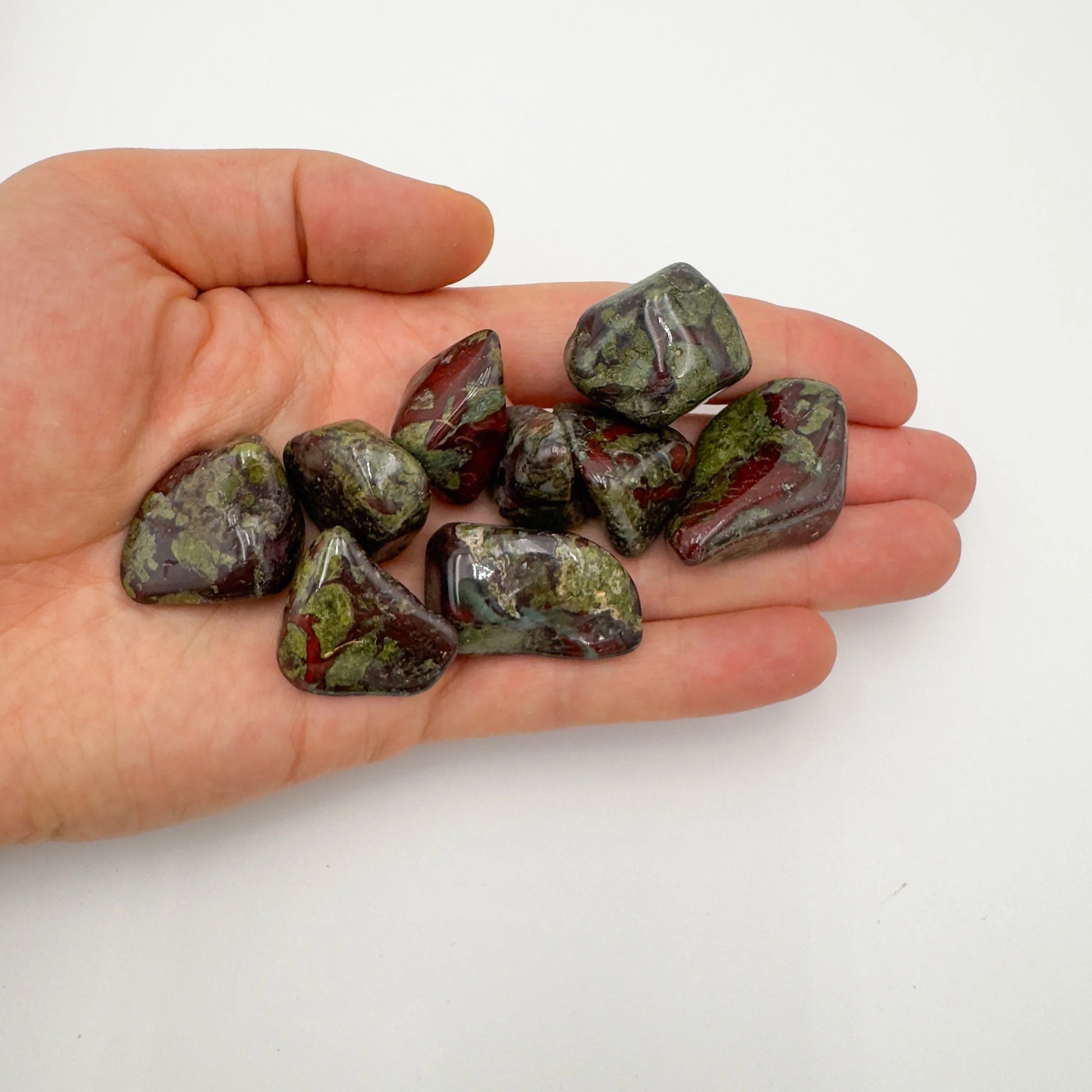 Natural light context of Dragon Bloodstone tumbled stone, from Limpopo, South Africa, with subtle natural color showing through.