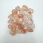 Up-close view of Grade AA Fire Quartz tumbled stone, showing natural sheen, carried for Grounding and Confidence.