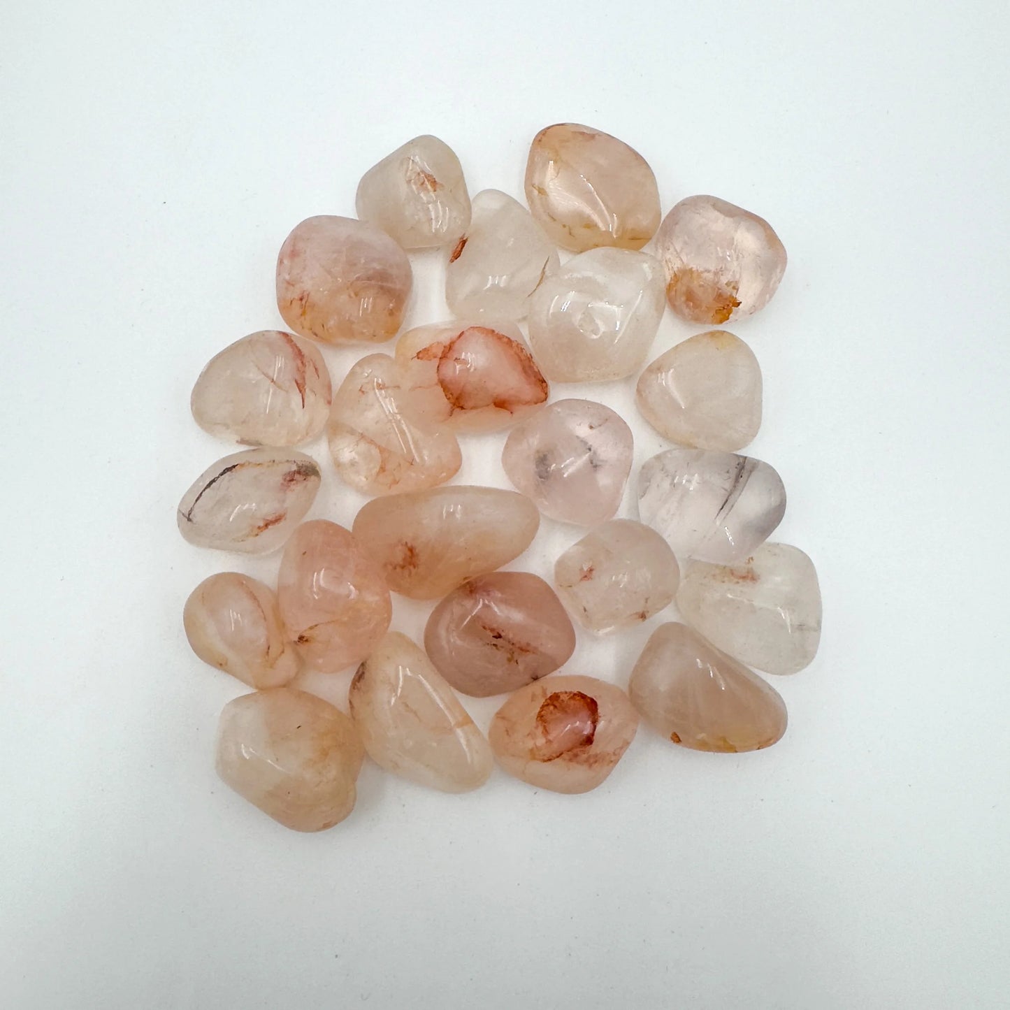 Up-close view of Grade AA Fire Quartz tumbled stone, showing natural sheen, carried for Grounding and Confidence.