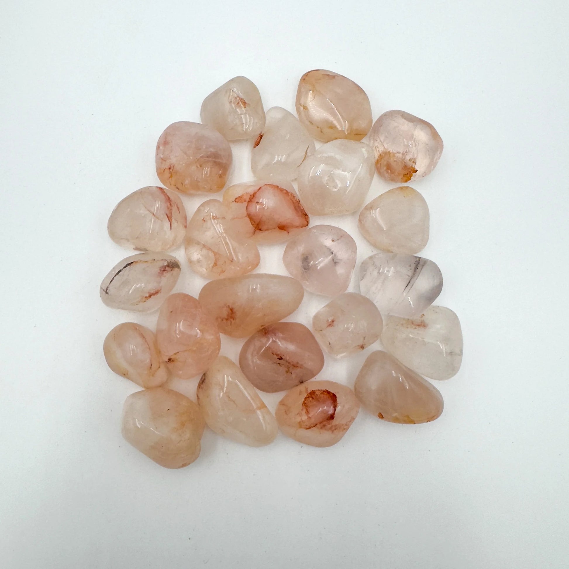 Up-close view of Grade AA Fire Quartz tumbled stone, showing natural sheen, carried for Grounding and Confidence.
