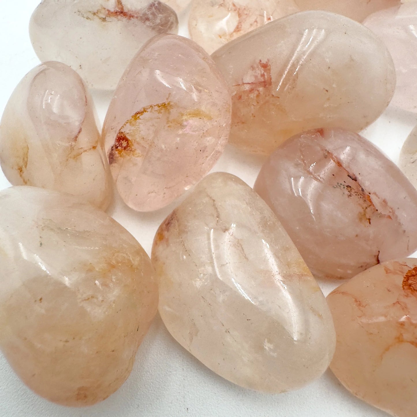 Bottom side of Fire Quartz tumbled stone, showing translucent edges, sourced from Alaotra-Mangoro, Madagascar.