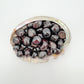 Up-close view of Garnet tumbled stone, kept close for Energy, showing natural inclusions.