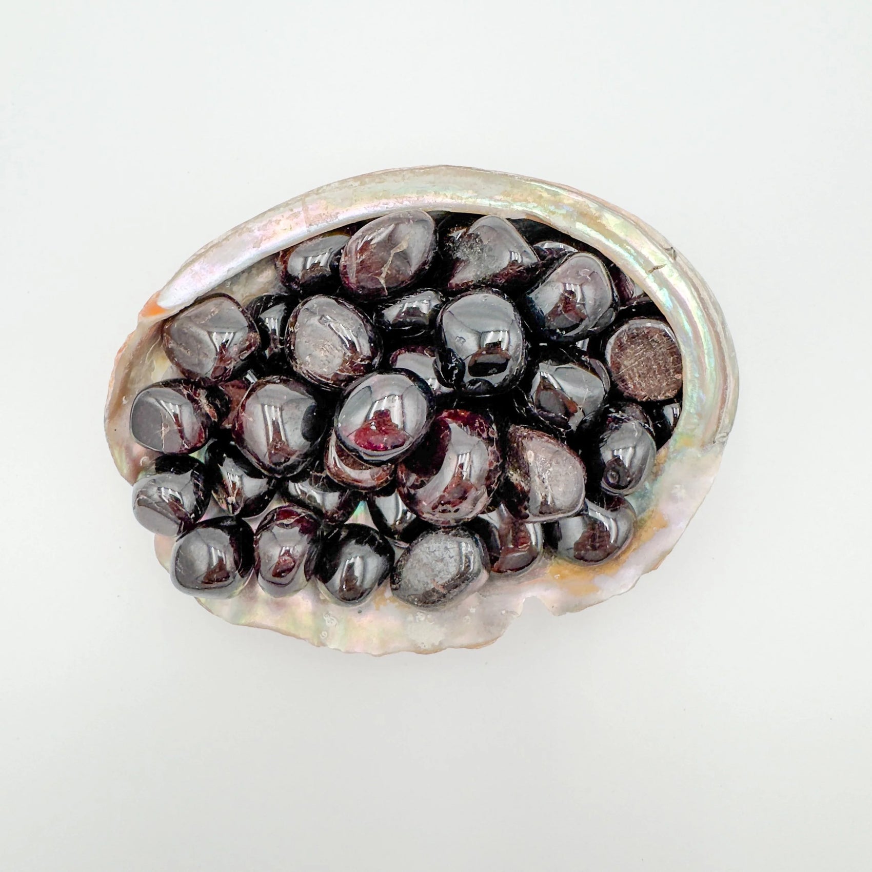 Up-close view of Garnet tumbled stone, kept close for Energy, showing natural inclusions.