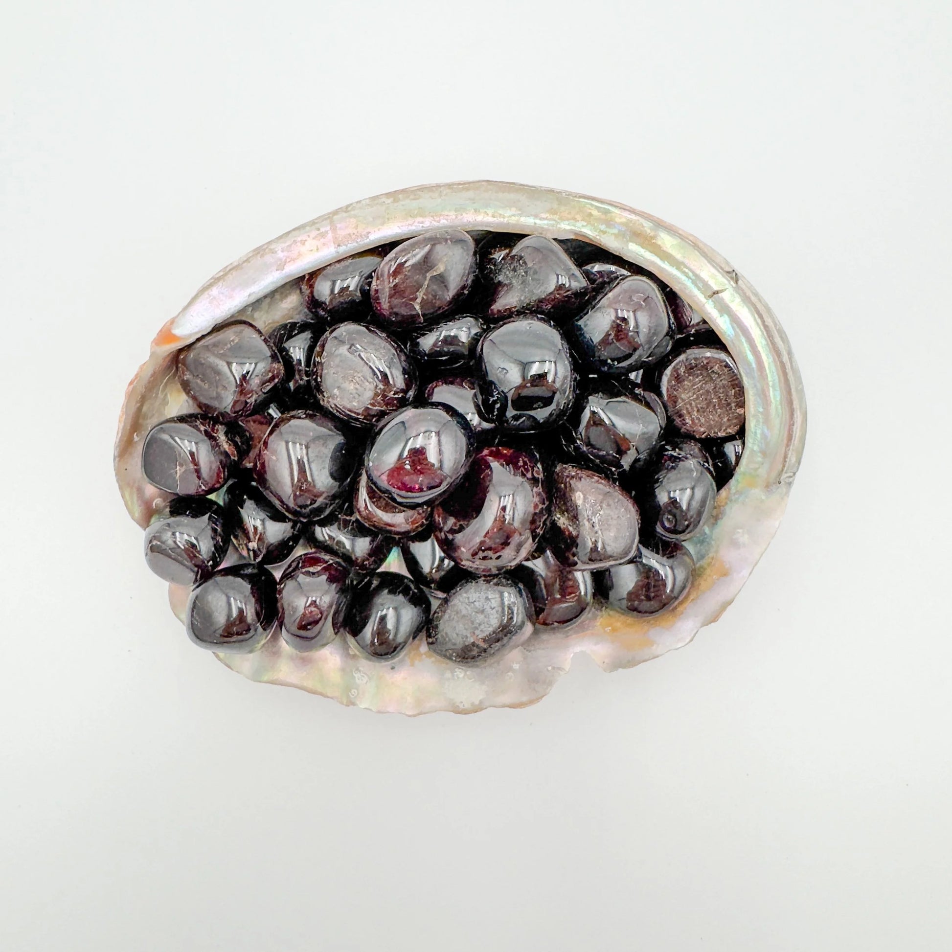 Up-close view of Garnet tumbled stone, kept close for Energy, showing natural inclusions.
