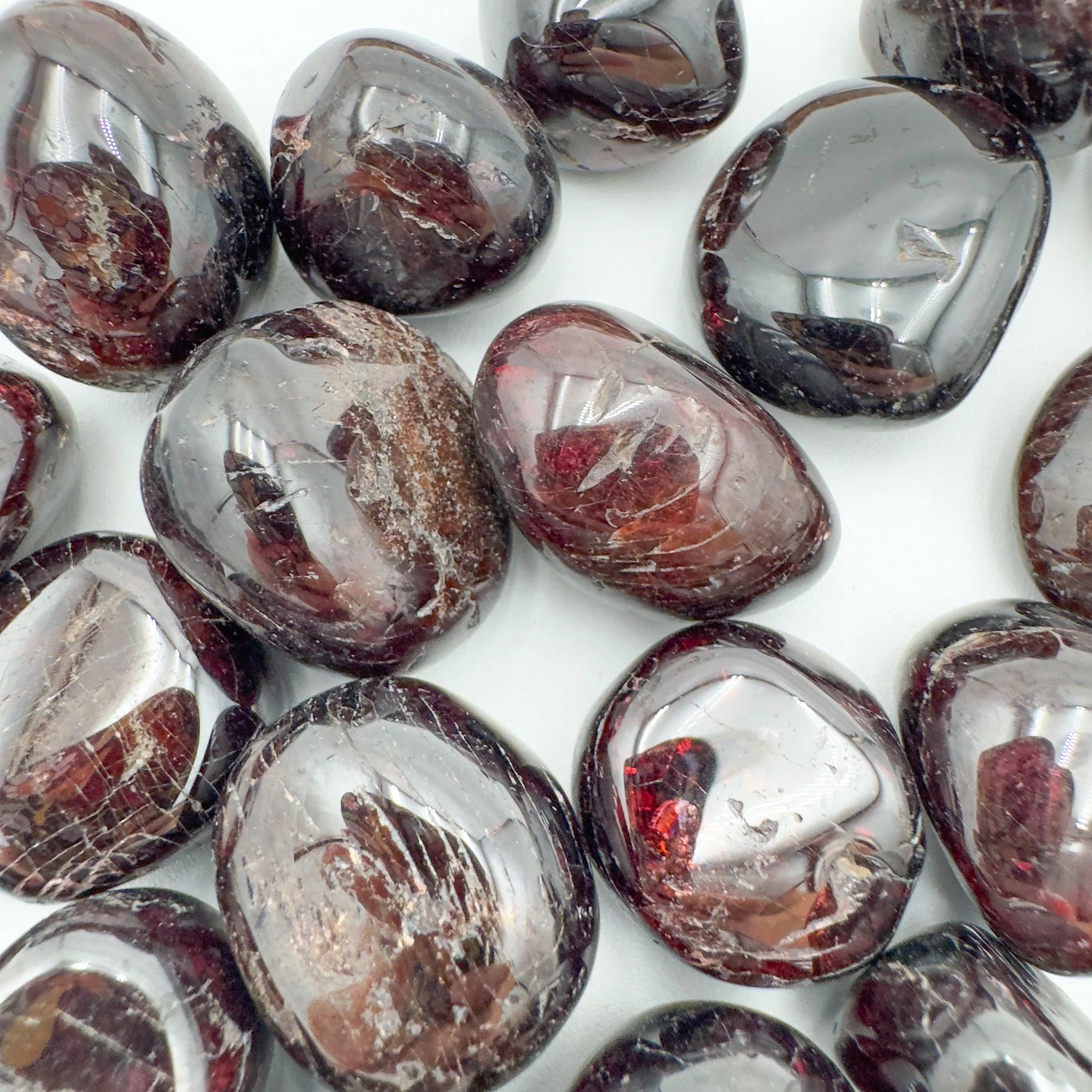 Hand-scale shot of a single Garnet tumbled stone hand-selected from Nsipe, Malawi.