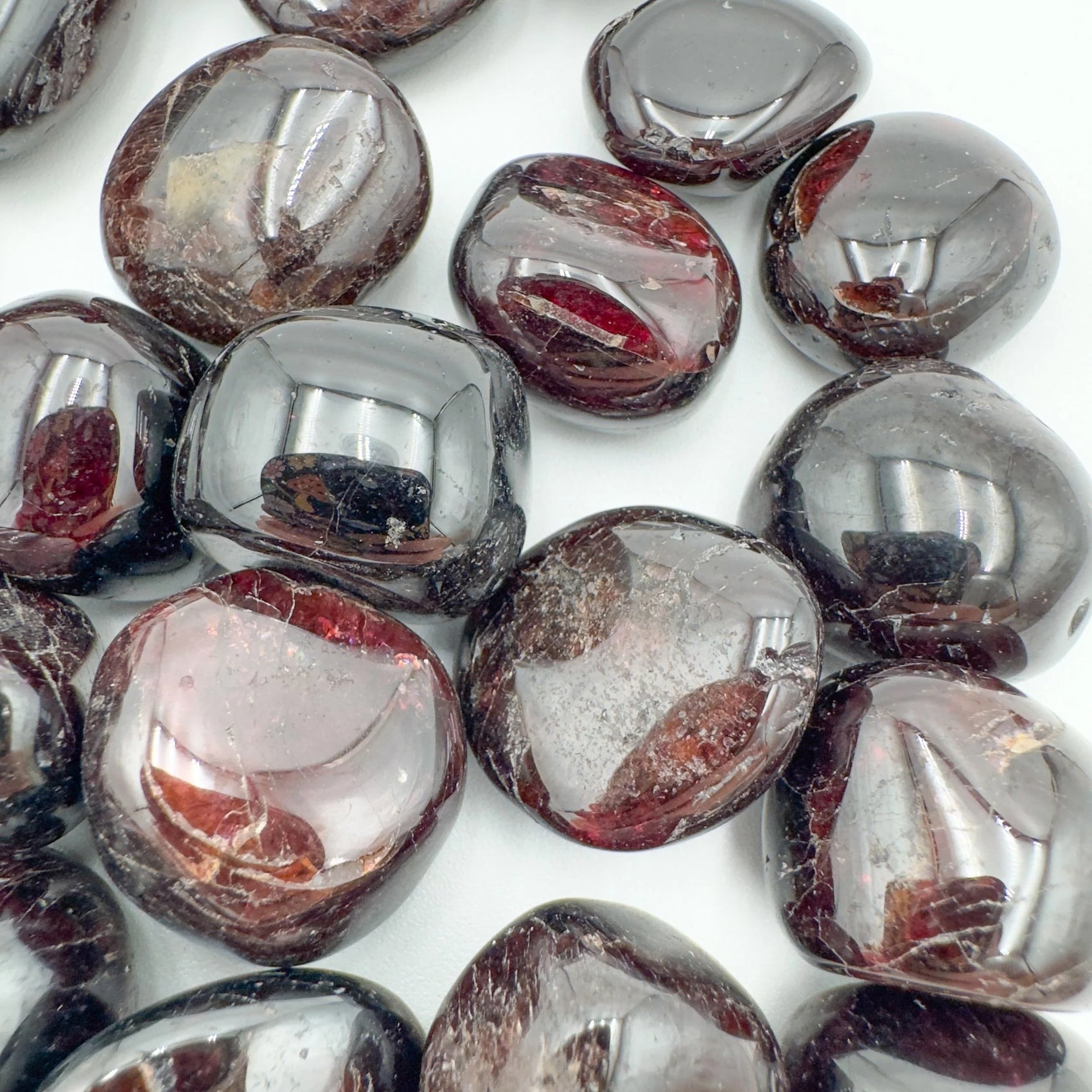 Quiet study of Garnet tumbled stone, from Nsipe, Malawi, captured against a quiet backdrop.