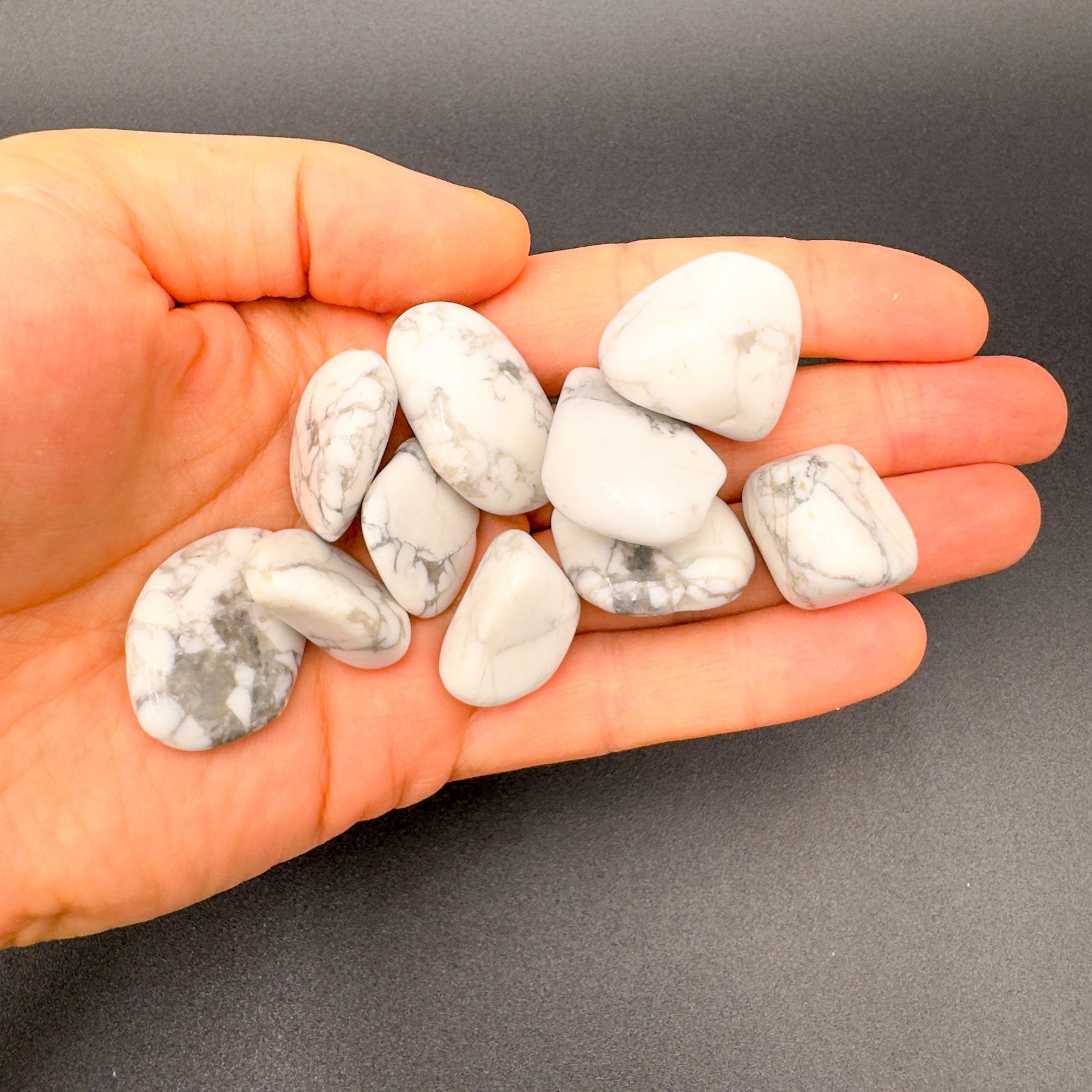 In-hand view of a Howlite tumbled stone, hand-selected from Masvingo, Zimbabwe.