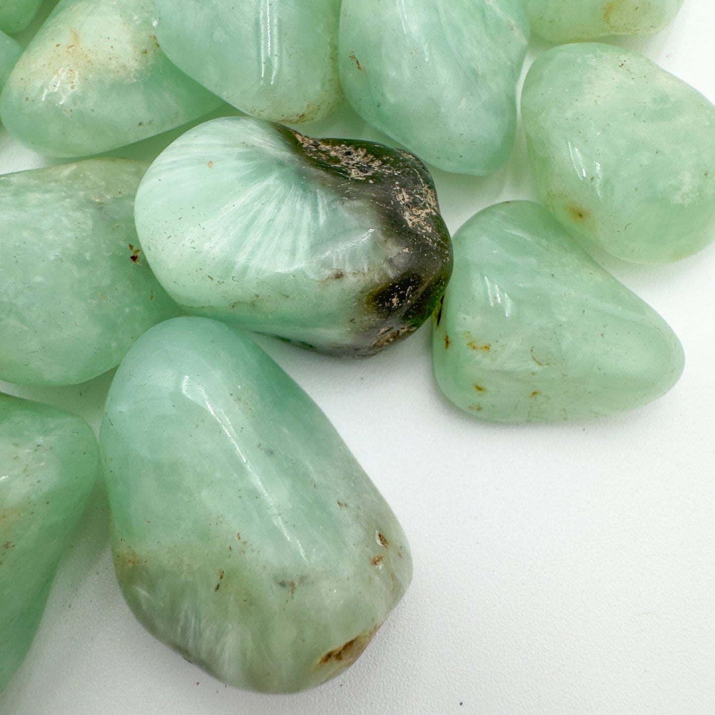 Profile shot of Prehnite tumbled stone, sourced from Namibia, showing natural sheen.
