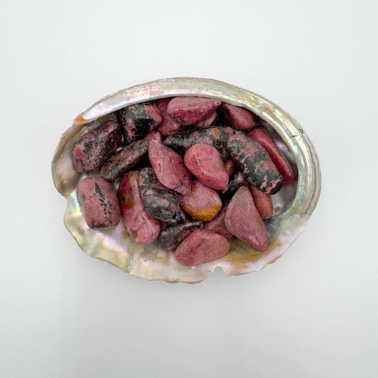 Tight crop of pink Rhodonite tumbled stone, Zimbabwe-sourced, showing characteristic patterning.