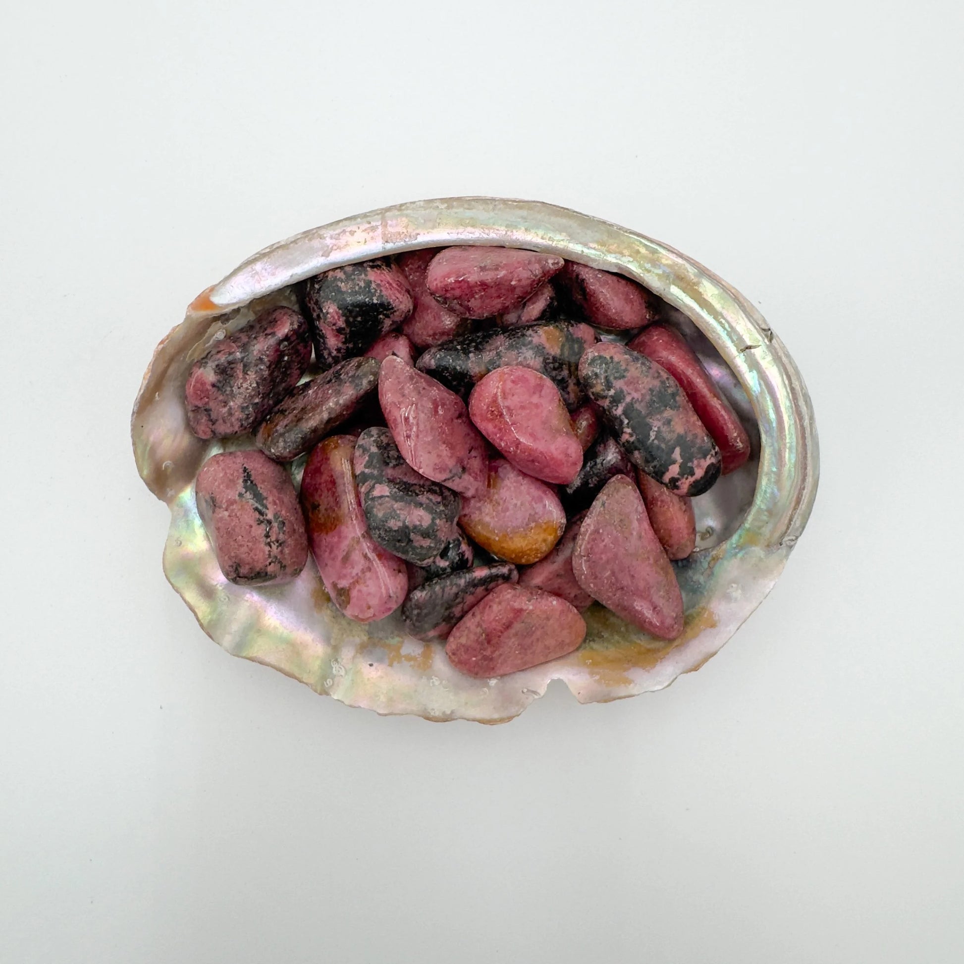 Tight crop of pink Rhodonite tumbled stone, Zimbabwe-sourced, showing characteristic patterning.