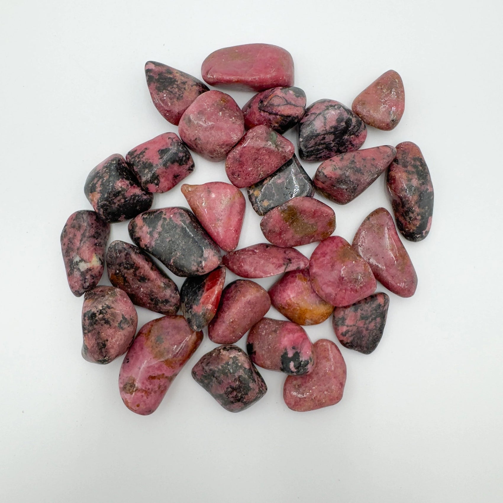 Close-up of Rhodonite tumbled stone from Zimbabwe, soothing wellness stone for Emotional Healing