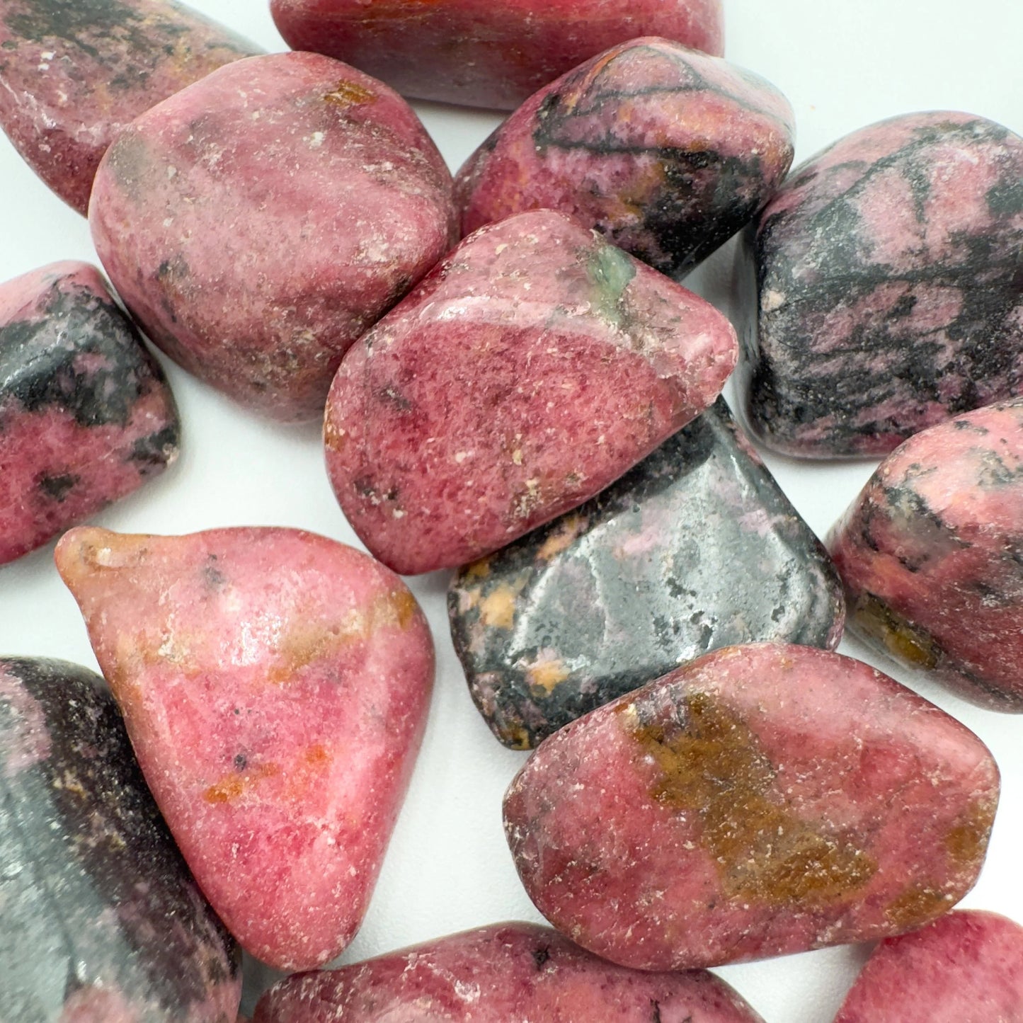 Underside view of Rhodonite tumbled stone, sourced from Masvingo, Zimbabwe, worked with for Emotional Healing and Love.