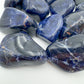 Lateral view of Sodalite tumbled stone, showing natural sheen.