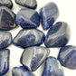 Hand-held view of a single Sodalite tumbled stone Namibia-sourced, from Namibia.