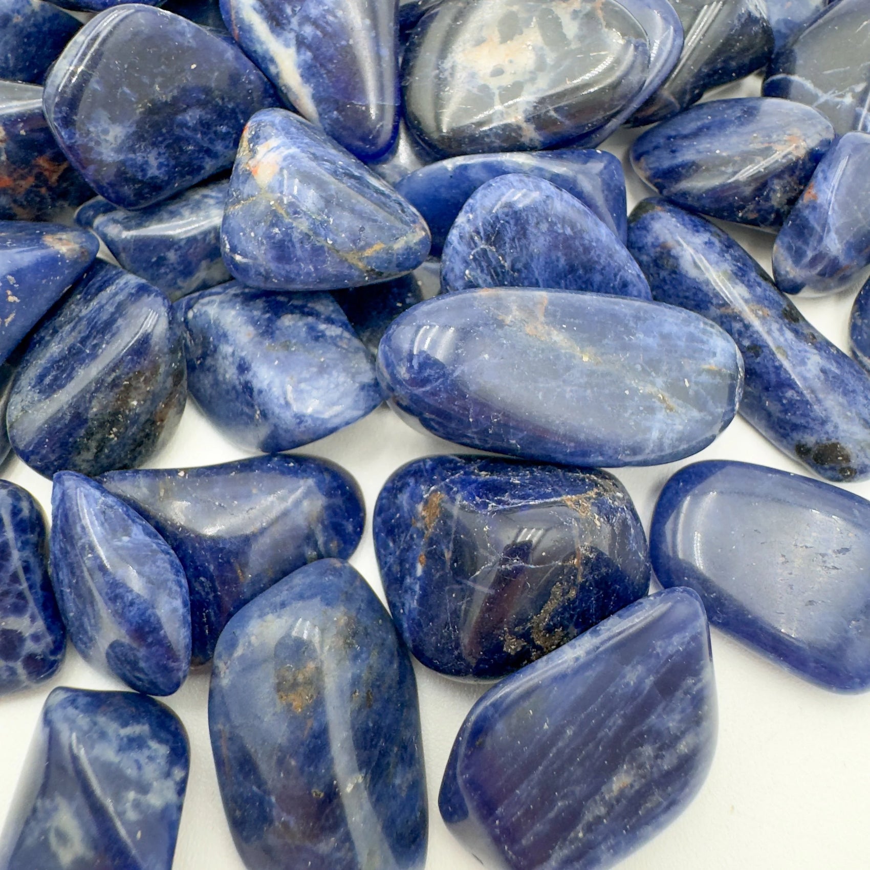 Side-on view of Sodalite tumbled stone, worked with for Focus, from Kunene, Namibia.