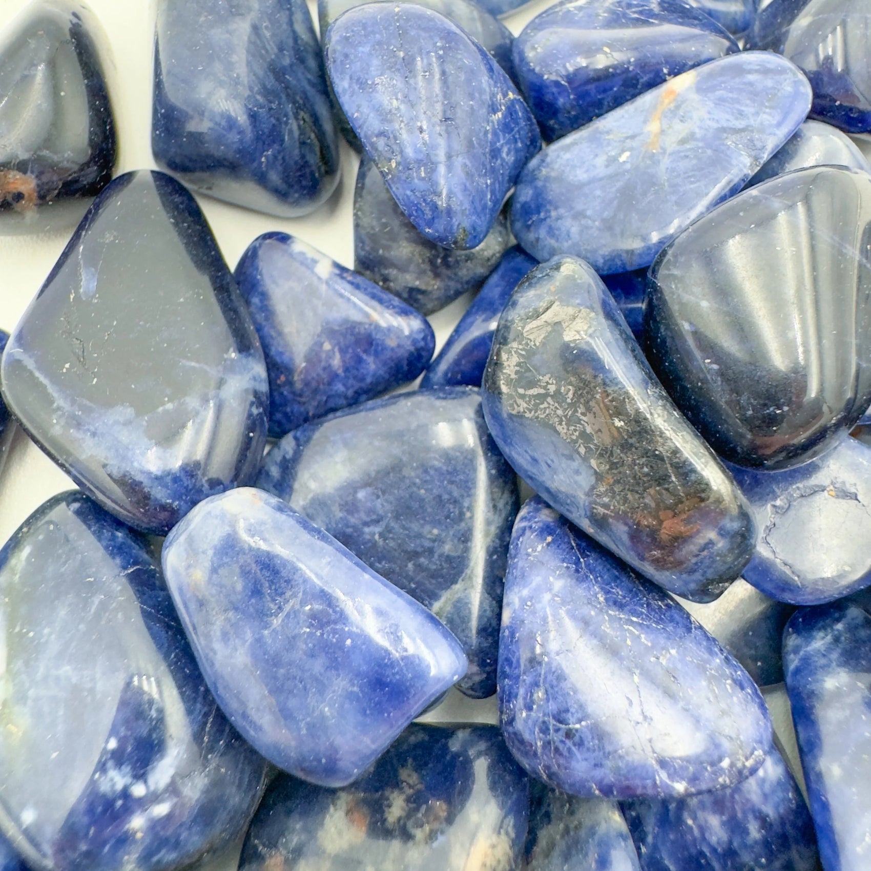 Palm-scale view of a single Sodalite tumbled stone sourced from Kunene, Namibia.
