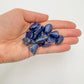 Display context of Sodalite tumbled stone, with hand-sized presence.