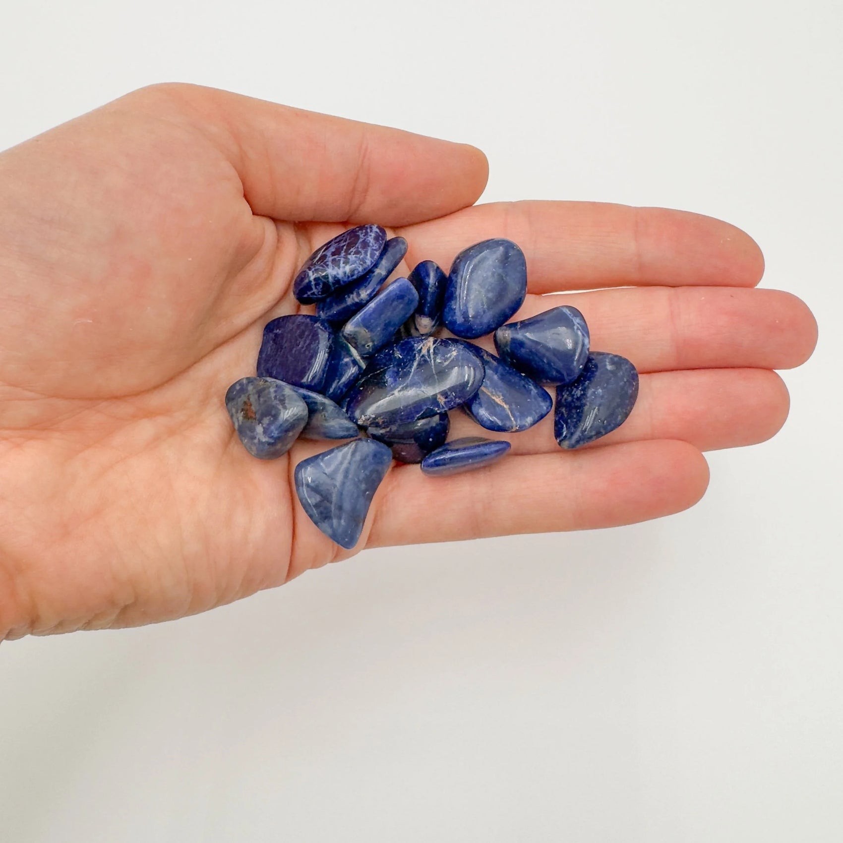 Display context of Sodalite tumbled stone, with hand-sized presence.