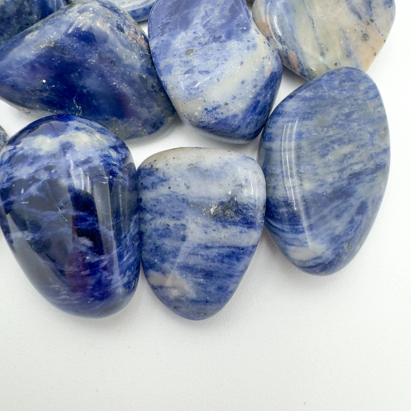 Sideways view of Sodalite tumbled stone, traditionally used for Focus and Intuition.
