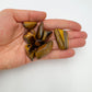 Held in hand is a Tiger Eye tumbled stone, from Northern Cape, South Africa, set to give a sense of weight.