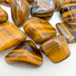 Side profile of Tiger Eye tumbled stone, sourced from Northern Cape, South Africa, worked with for Confidence.