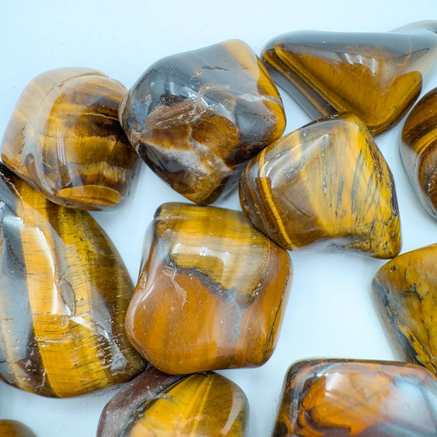 Palm-scale view of a Tiger Eye tumbled stone turned to for Confidence, from South Africa.
