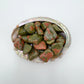 Near view of Grade AA Unakite tumbled stone, linked to Emotional Healing and Healing, showing natural texture.